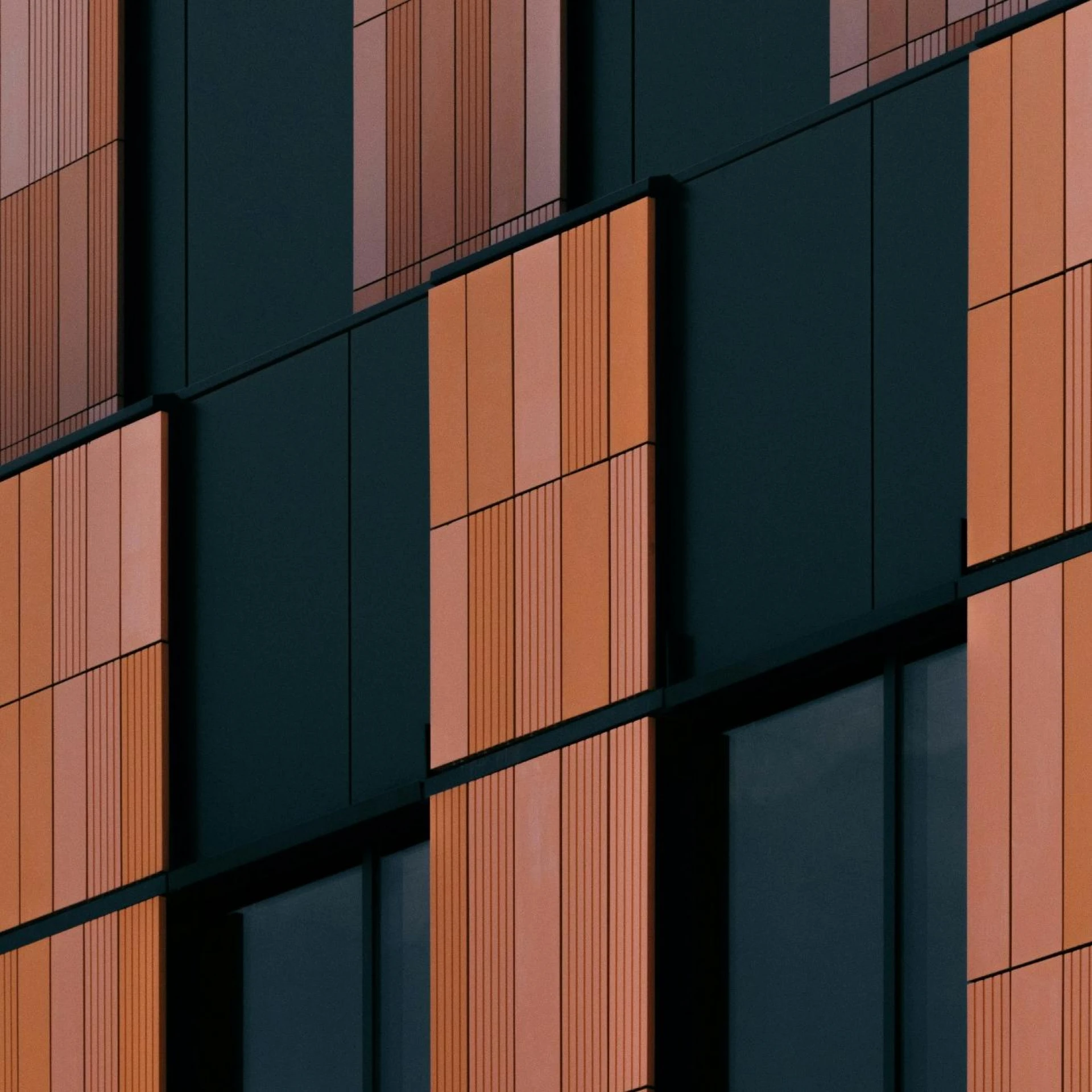 Close-up of a building facade with orange and black panels, showing a modern architectural design