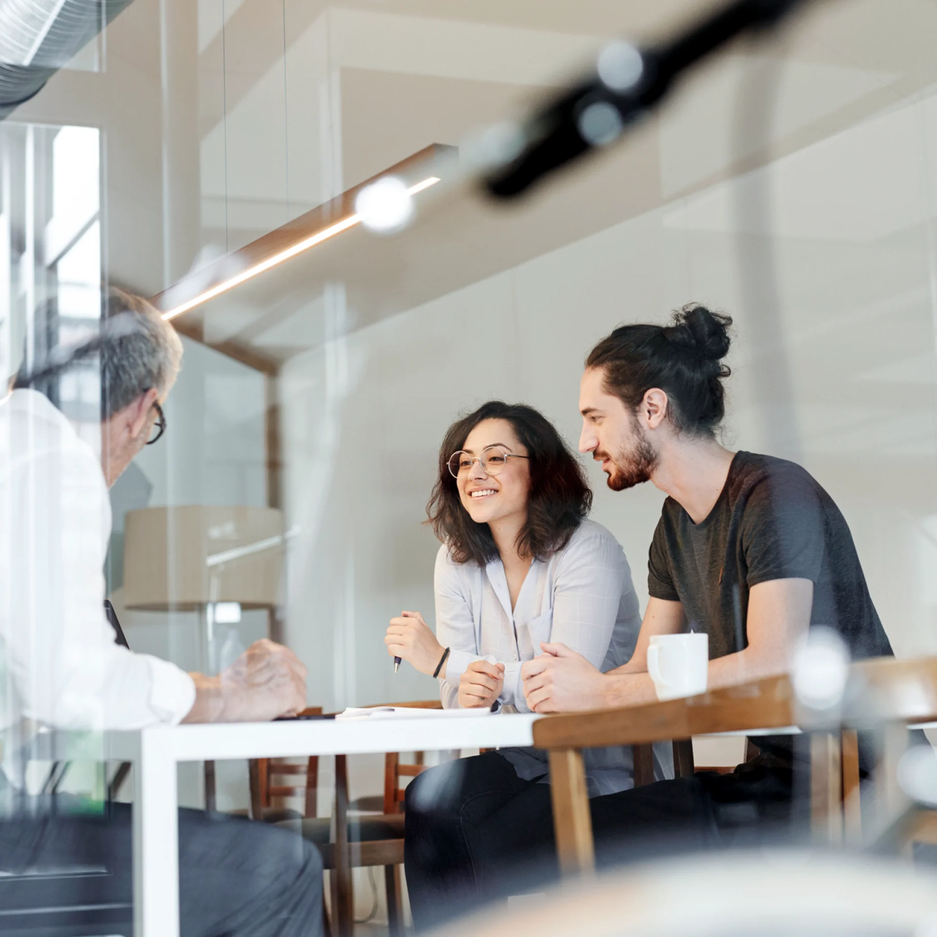 stock image of people sitting around a table talking, dressed in business casual attire.